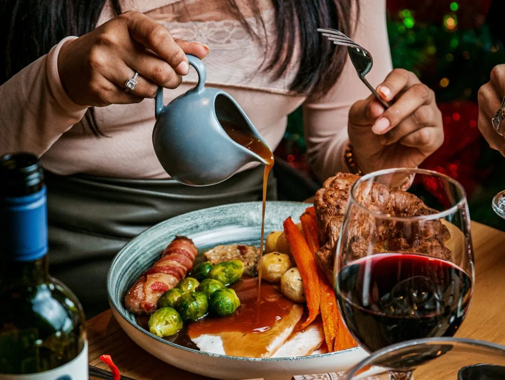 Someone pouring gravy on Christmas dinner