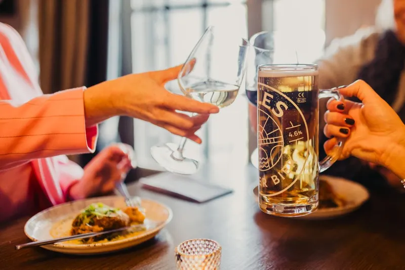 Clinking glasses of beer and wine