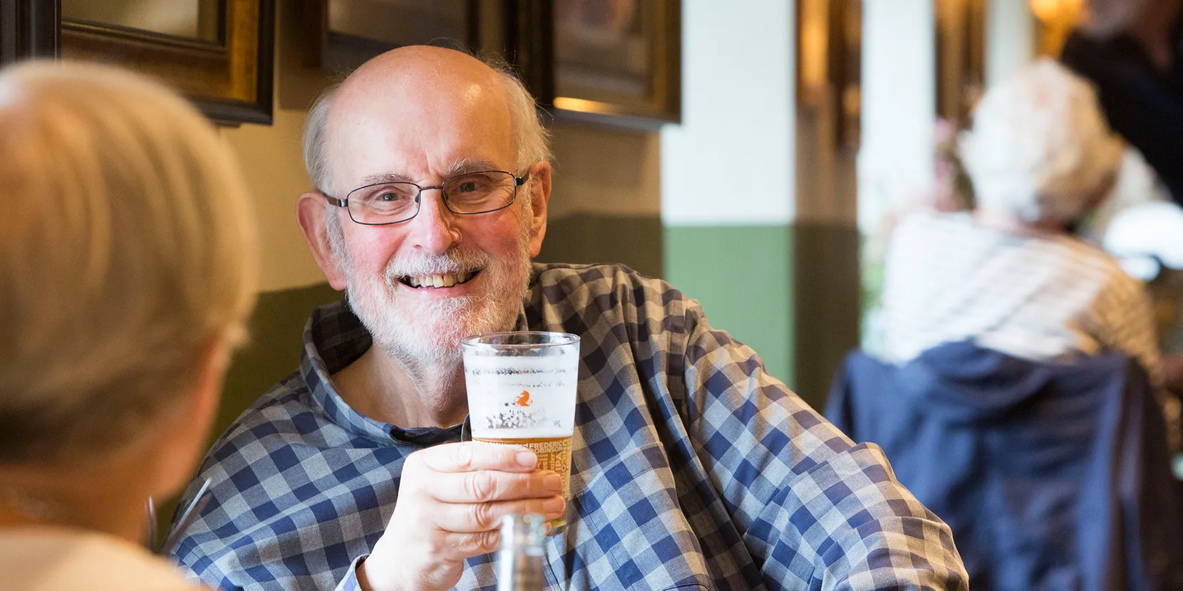 An older man holding a beer